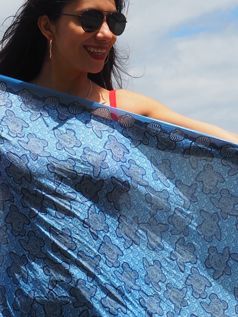 Blue turtles made out of shells arranged to look like turtles on a blue background printed on 100% indian cotton voile sarong light weight 2.1 meters long prefect for summer on the beach.