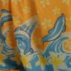dolphins swimming and diving through a daphodil sea of frangipanis handprinted on 100% light weight indian cotton voile perfect for summer or around the pool