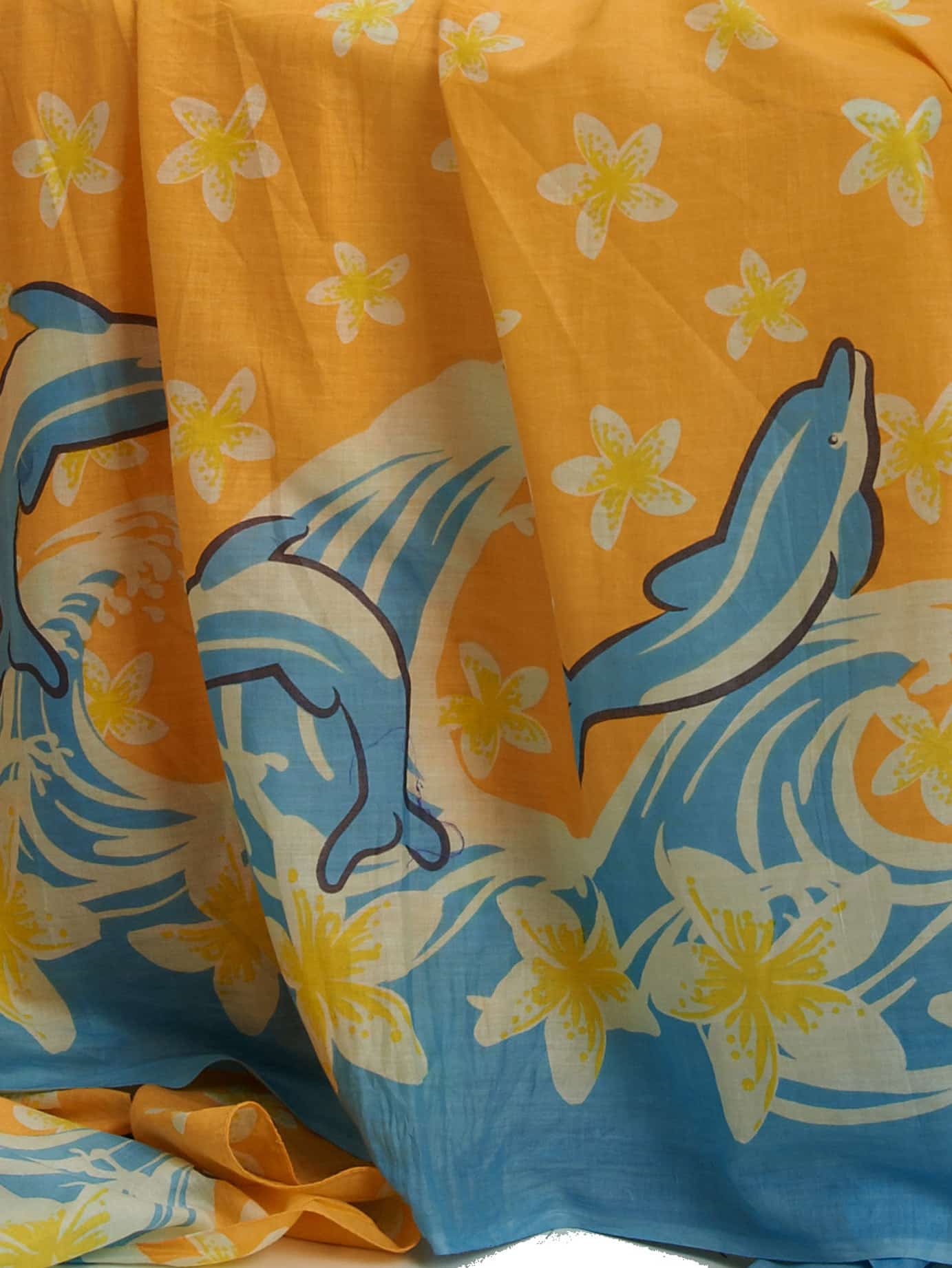 dolphins swimming and diving through a daphodil sea of frangipanis handprinted on 100% light weight indian cotton voile perfect for summer or around the pool